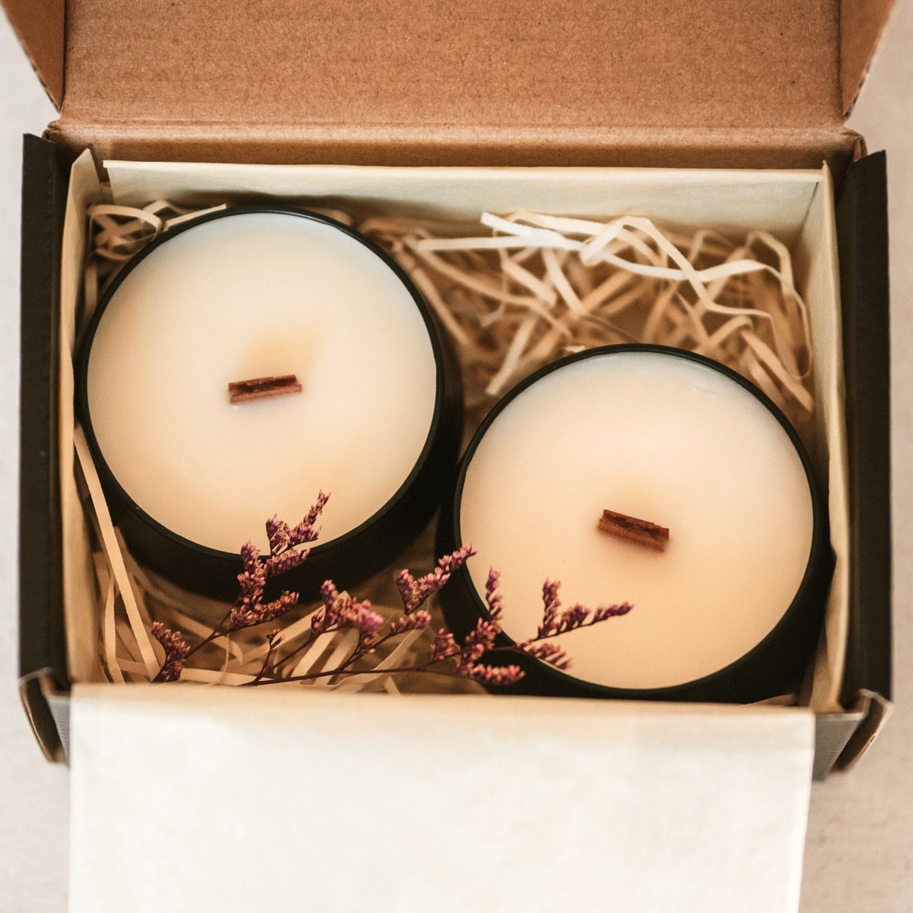 Two candles in a box with decorative elements on a light background