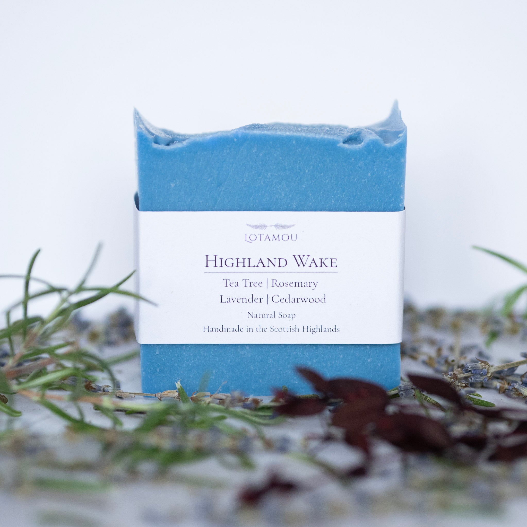 Blue soap bar with a white label on a blurred natural background