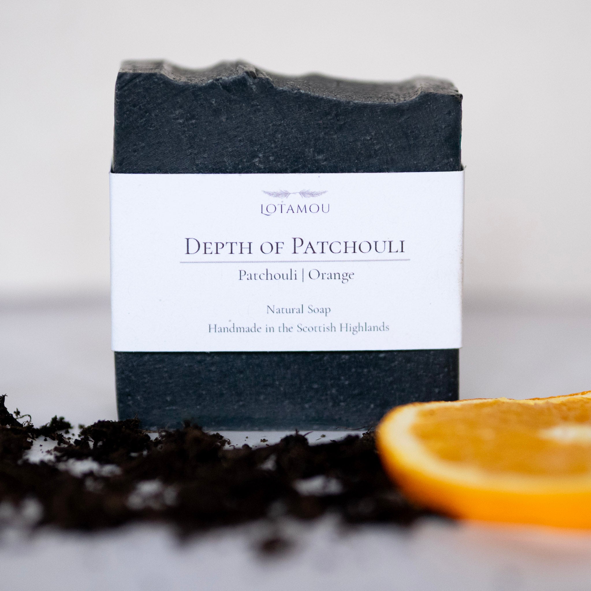 Bar of soap with a label featuring 'Lotamou' on a white background with an orange slice.
