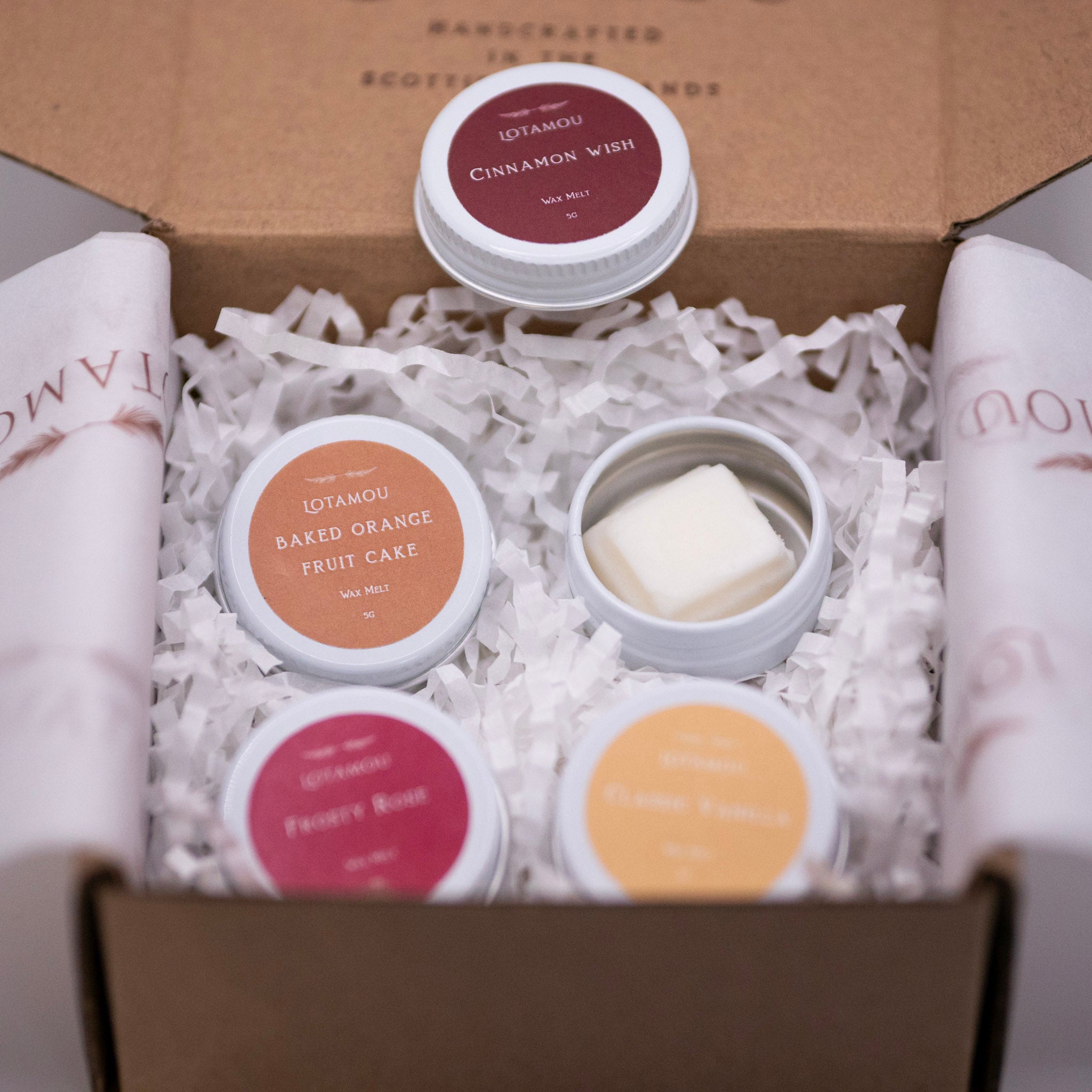 Collection of scented candles in a box with visible branding