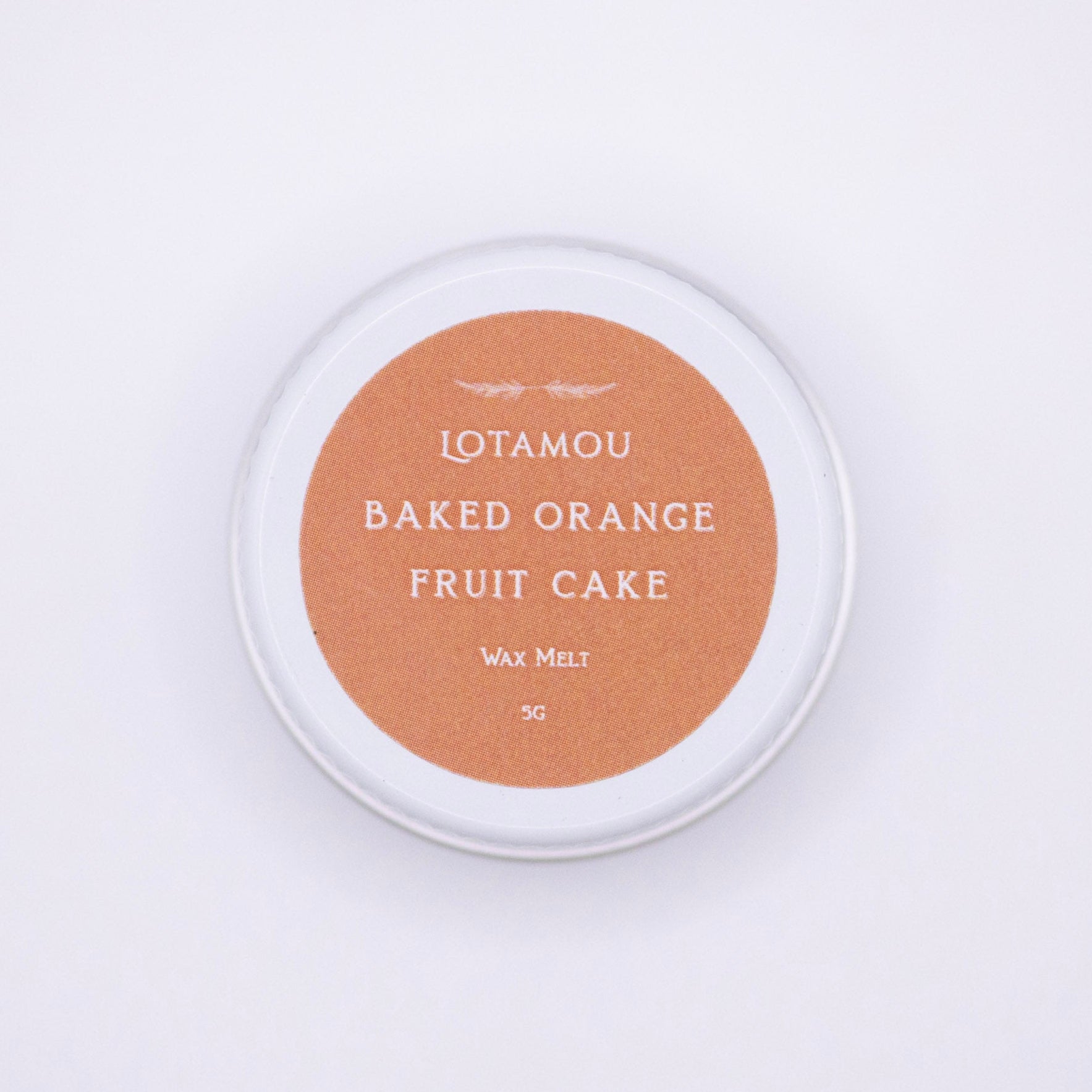 Wax melt container labeled 'Baked Orange Fruit Cake' by Lotamou on a white background