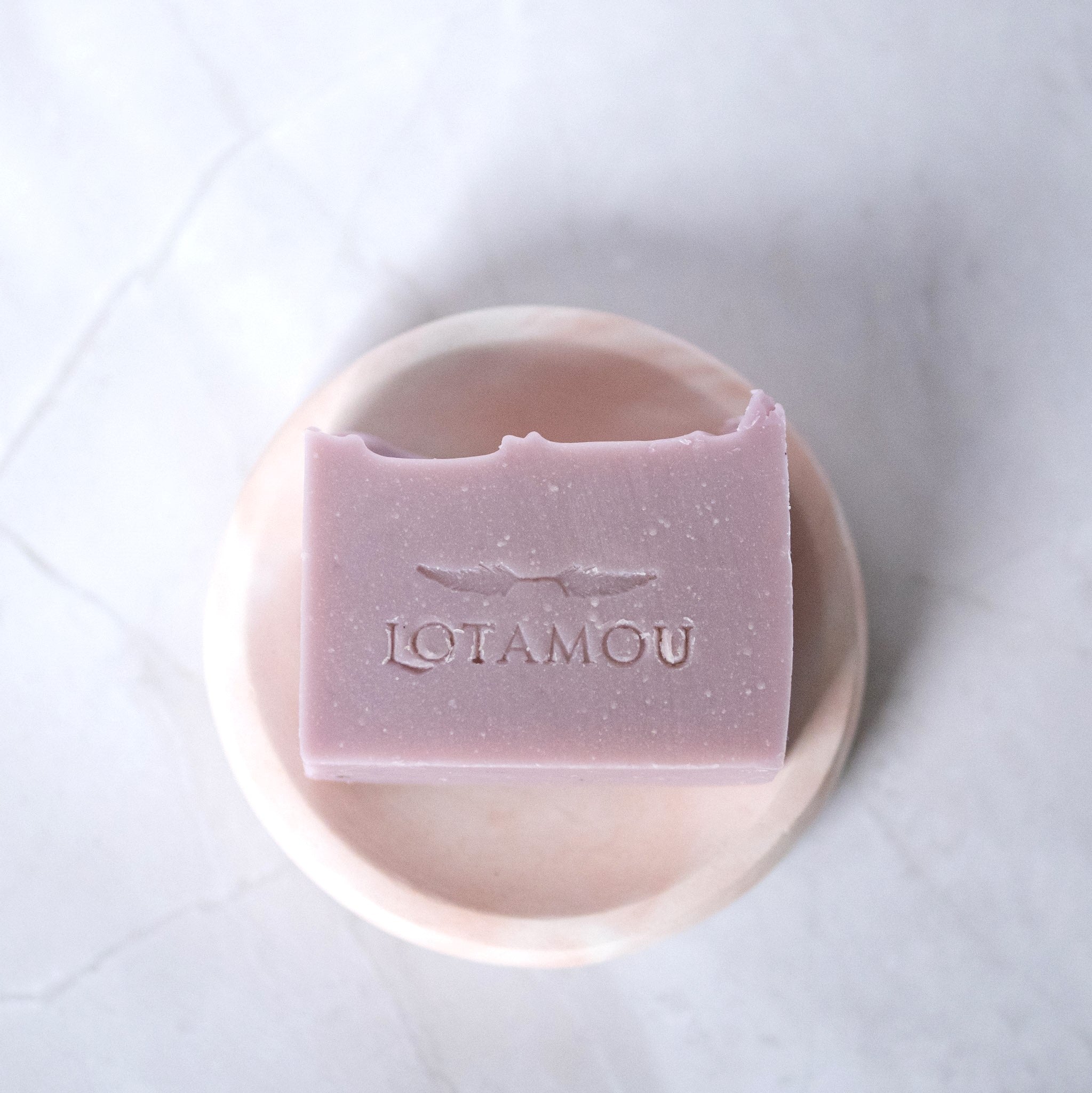 Purple soap bar with 'LOTAMOU' branding on a white background
