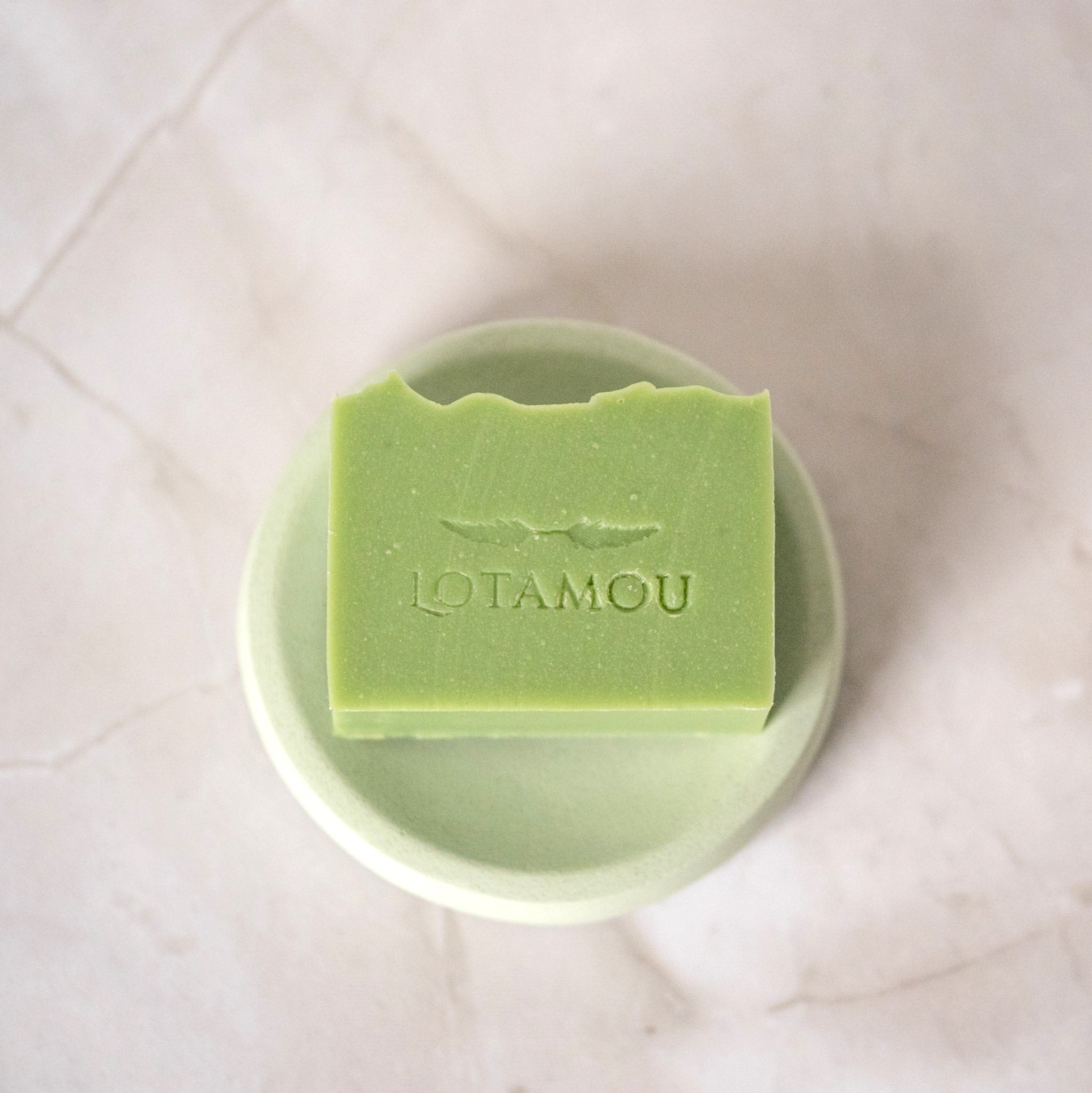 Green soap bar with 'LOTAMOU' branding on a white background
