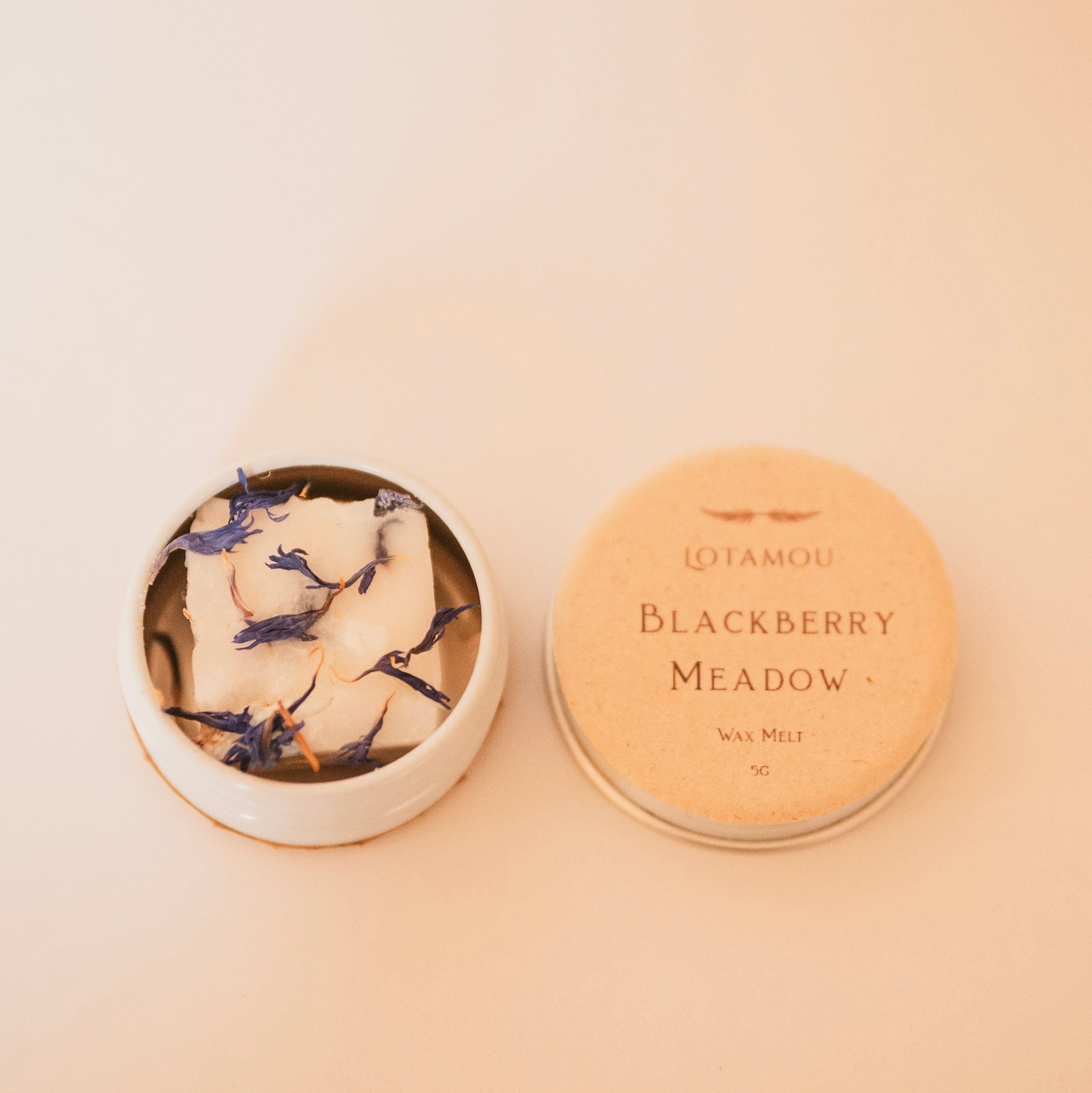 Wax melt container with decorative lid featuring floral design on a beige background